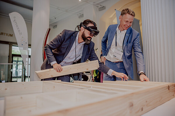 Wissenschaftsminister Sebastian Gemkow lässt sich von HTWK-Professor Alexander Stahr zeigen, wie Augmented Reality die Montage von Holztragwerken vereinfacht. 